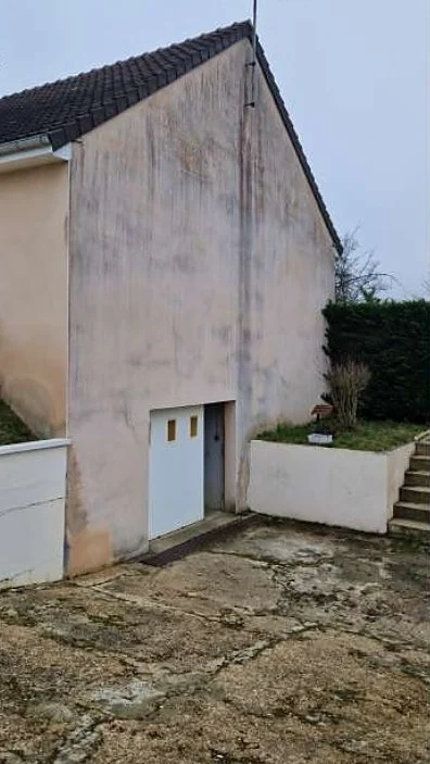 Le même pignon avant le nettoyage, enduit grisé et taché